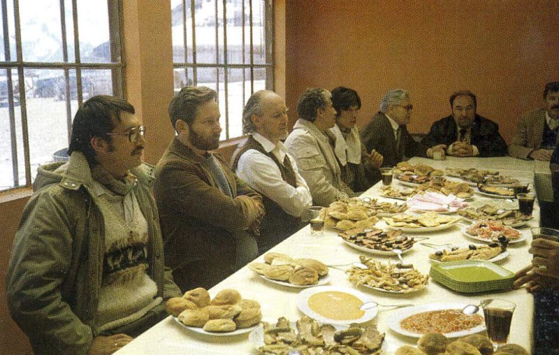 Una mesa larga con comensales en el comedor del Laboratorio; por la ventana, nieve.