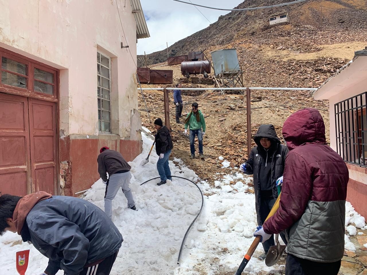 Estudiantes retiran nieve de un acceso