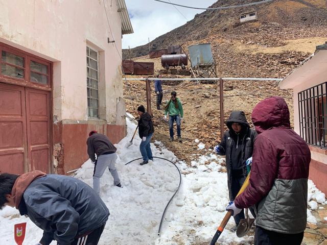 Estudiantes retiran nieve de un acceso