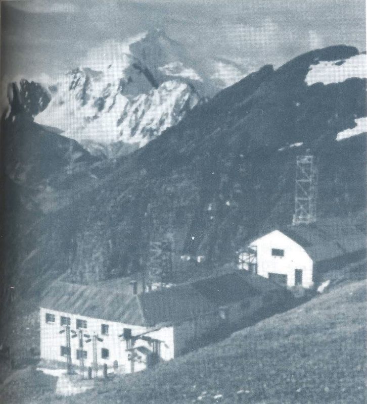 Los edificios blancos del Laboratorio en la ladera, con una cumbre nevada al fondo.