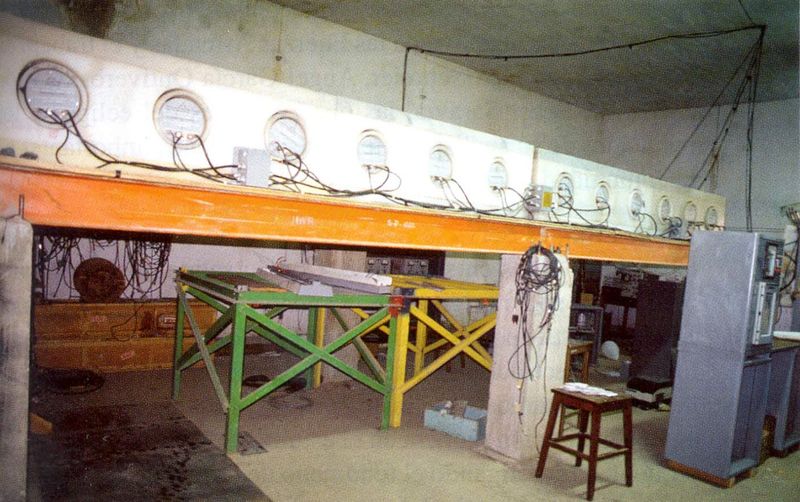 Hilera de contadores cilíndricos montados sobre una viga, en una sala de instrumentos.